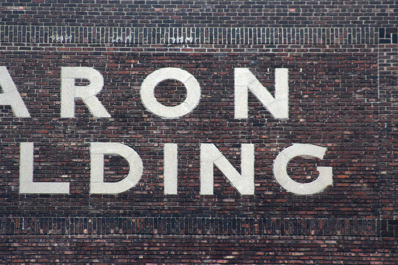 Inlaid limestone lettering on the side of the Caron Building