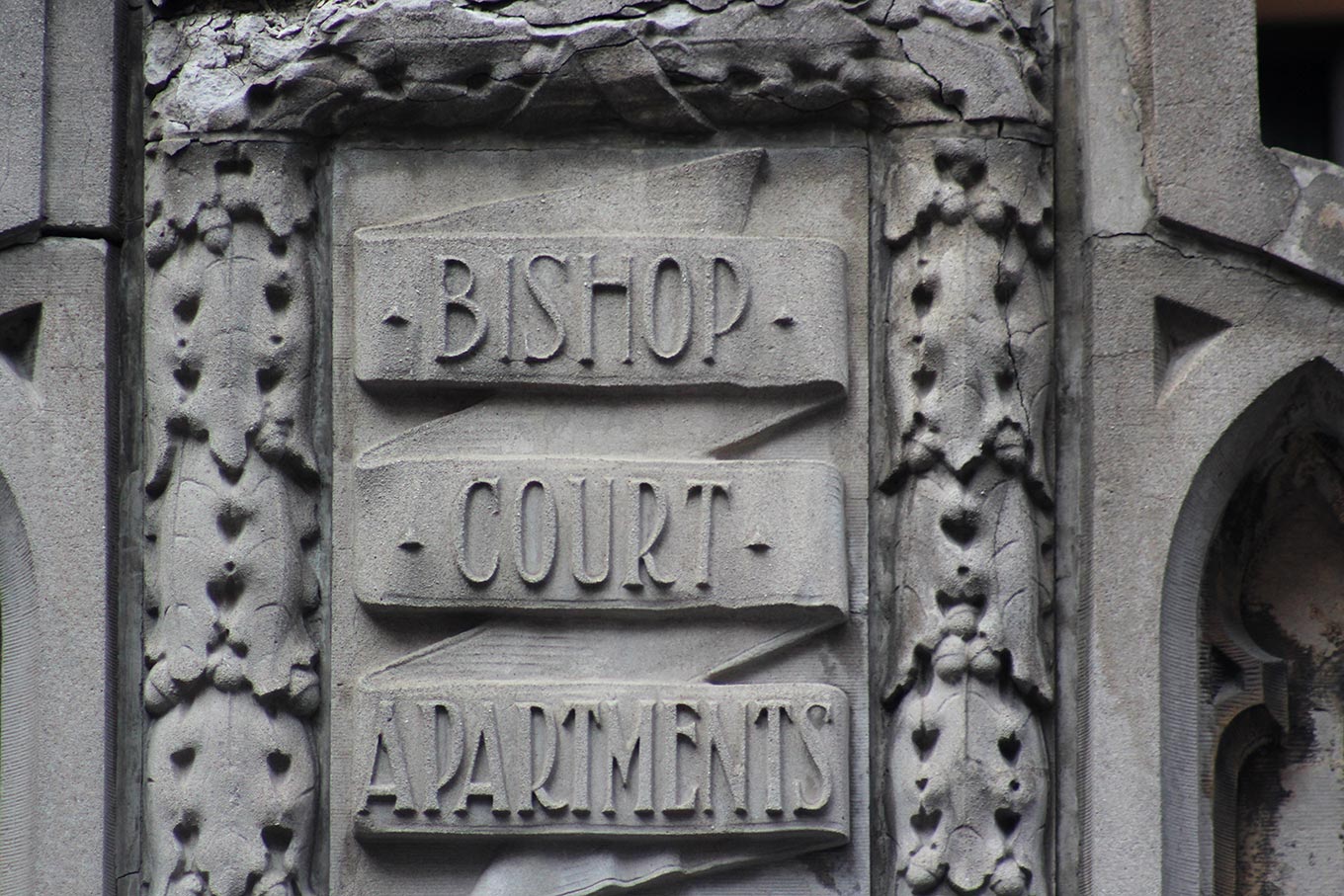 Raised sandstone inscription on the Bishop Court Apartments facade at the corner of rue Bishop and boulevard de Maisonneuve Ouest.